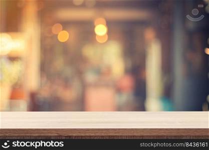 Empty wooden table for product placement or montage and blurred coffee shop backdrop.