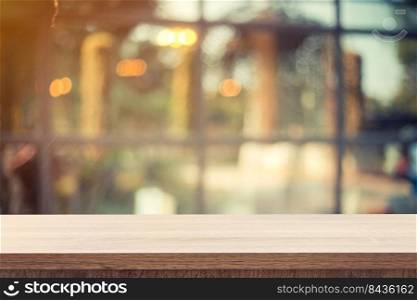 Empty wooden table for product placement or montage and blurred coffee shop backdrop.