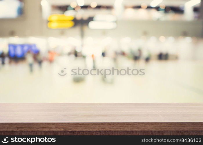 Empty wooden table for product placement or montage and blurred terminal department at airport background.