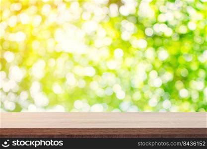 Empty wooden table for product placement or montage and green boken blurred background.
