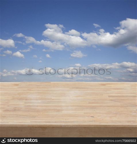 empty wooden table in a garden on blue sky background