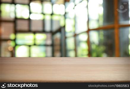 Empty wooden table in front of abstract blurred background of coffee shop . wood table in front can be used for display or montage your products.Mock up for display of product