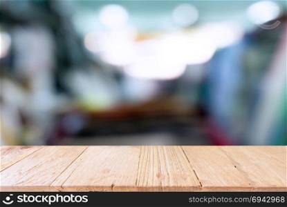 Empty wooden table in front of abstract blurred background of coffee shop . can be used for display Mock up of product.