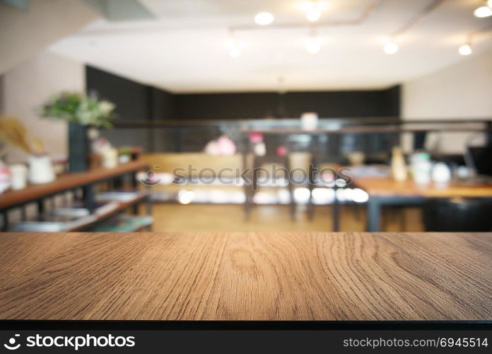 Empty wooden table in front of abstract blurred background of coffee shop . can be used for display or montage your products.Mock up for display of product