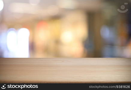 Empty wooden table in front of abstract blurred background of coffee shop . wood table in front can be used for display or montage your products.Mock up for display of product 