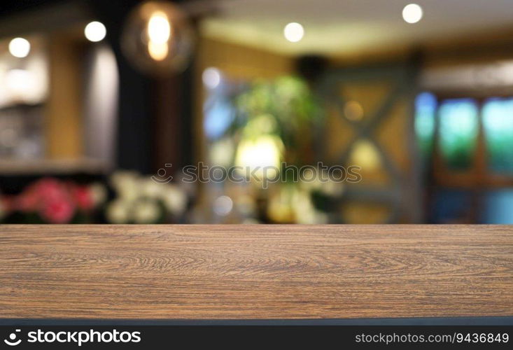 Empty wooden table in front of abstract blurred background of coffee shop . wood table in front can be used for display or montage your products.Mock up for display of product 