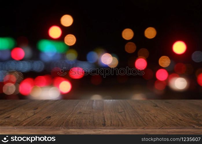 Empty wooden table in front of abstract blurred bokeh light of Cafe, restaurant at night