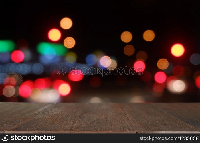 Empty wooden table in front of abstract blurred bokeh light of Cafe, restaurant at night.