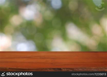 Empty wooden table in front of abstract blurred green bokeh light of garden and nature light background. For montage product display or design key visual layout - Image