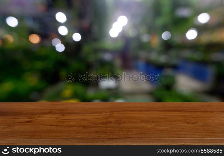 Empty wooden table in front of abstract blurred green of garden and house background. For montage product display or design key visual layout - Image