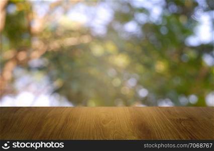 Empty wooden table in front of abstract blurred green of garden and nature light background. For montage product display or design key visual layout - Image