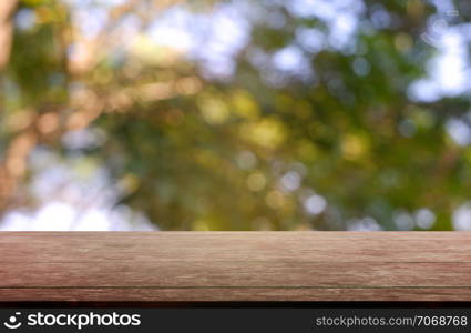 Empty wooden table in front of abstract blurred green of garden and nature light background. For montage product display or design key visual layout - Image