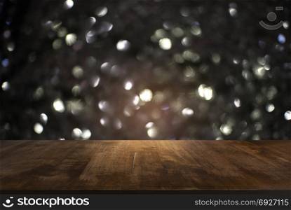 Empty wooden table in front of black and gold glitter lights background . can be used for display or montage your products.Mock up for display of product