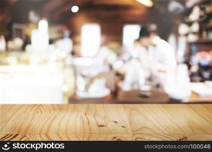 empty wooden table in front of blur coffee shop cafe or restaurant background