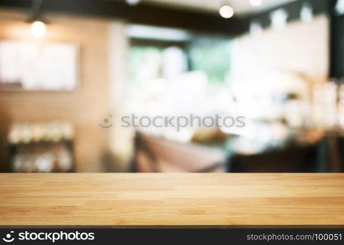 empty wooden table in front of blur coffee shop cafe or restaurant background