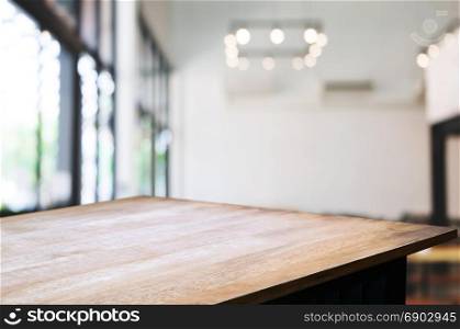 empty wooden table in front of blurred coffee shop cafe or workplace background