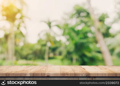 Empty wooden table top and Abstract blurred light bokeh and blur background of garden trees in sunlight. product display template with copy space.