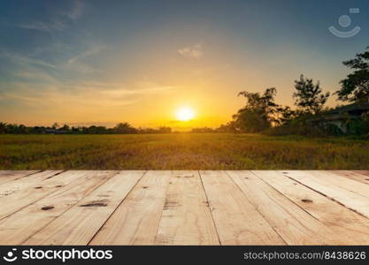 Empty wooden table top and display montage with blur background field sunset.