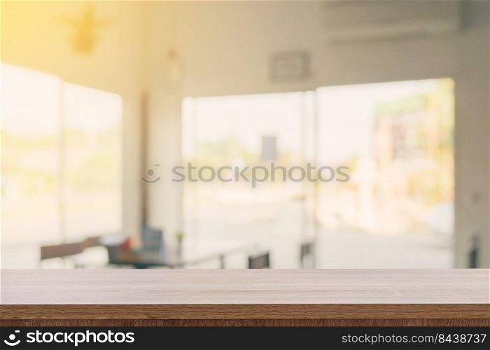 Empty wooden table top with blurred modern coffee shop background for product display and montage.