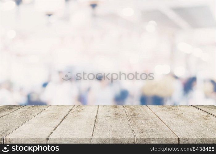 Empty wooden table with blurred abstract people on cafe on restaurant background.