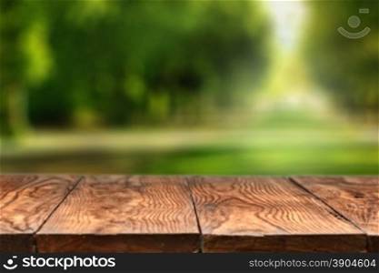 Empty wooden table with blurred city park on background, natural background with bokeh