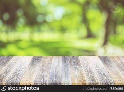 Empty wooden table with nature green outdoor background - can be used for display your products. summer spring concept.
