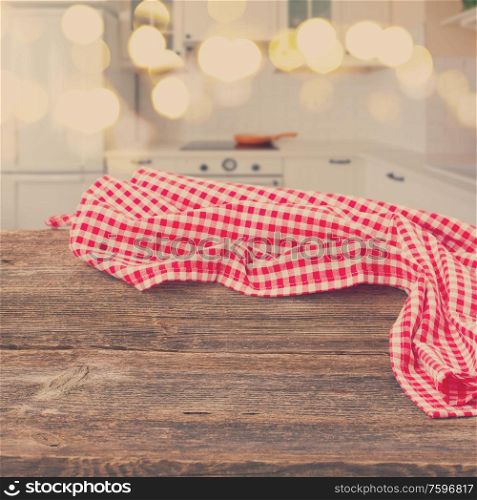 empty wooden table with red napkin in a light modern kitchen, retro toned. table in a kitchen