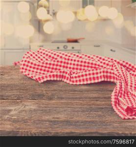 empty wooden table with red napkin in a light modern kitchen, retro toned. table in a kitchen
