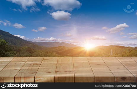 empty wooden tabletop with mountain and sunset sky background. countryside landscape.