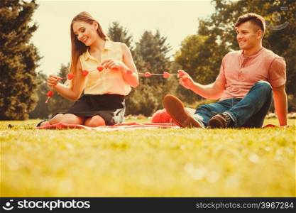 Enamoured couple in park. . Love romance relationship dating concept. Enamoured couple in park. Girl and boy in park on picnic.