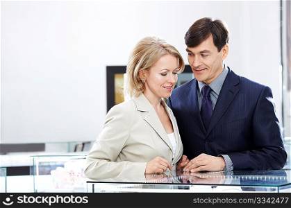 Enamoured couple of middle age in jeweller shop