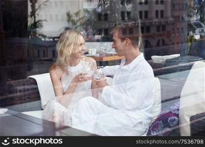 Enamoured young couple at restaurant through glass