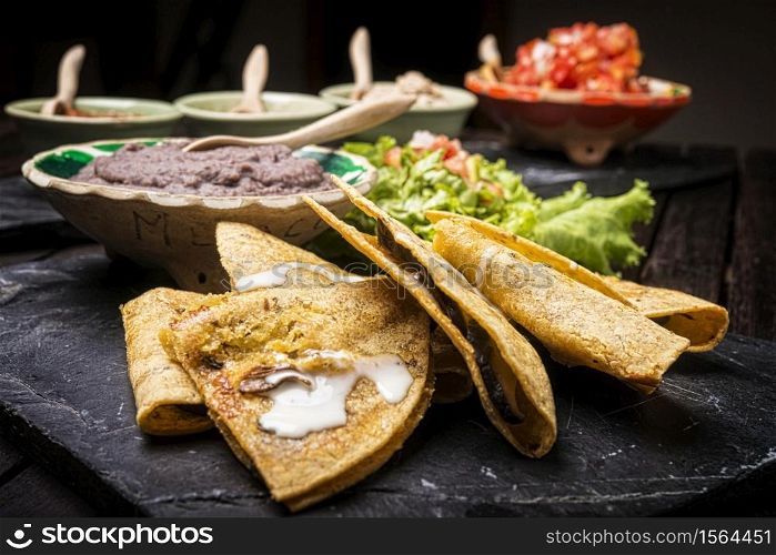 Enchiladas with mexican dips in background