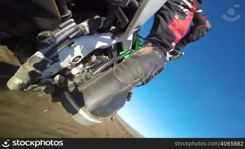 Enduro racer riding bike on dirt track rear wheel point of view