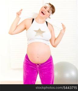 Energetic beautiful pregnant woman enjoying making sports at home&#xA;