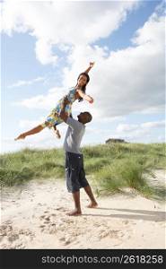 Energetic Young Couple Having Fun In Dunes By Beach