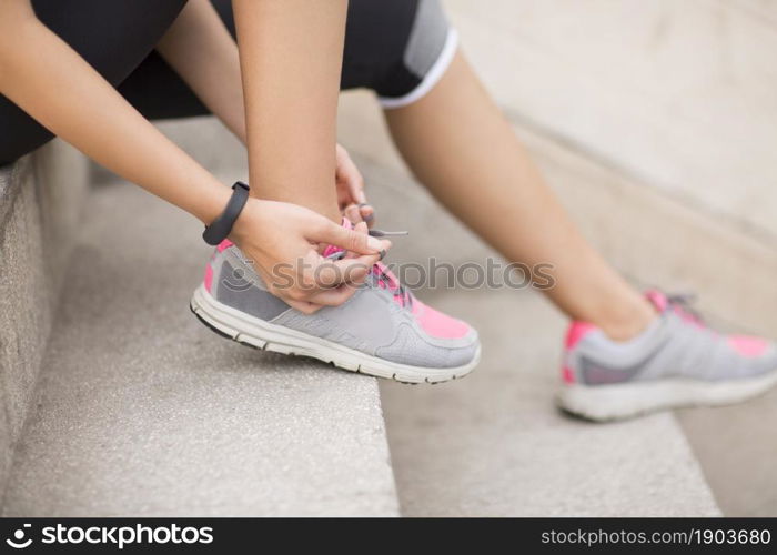 Energetic young woman tying her shoes