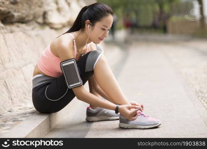 Energetic young woman tying her shoes