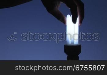 Energiesparlampe eindrehen, blauer Hintergrund