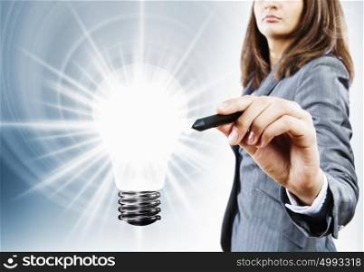 Energy concept. Close up of businesswoman touching light bulb