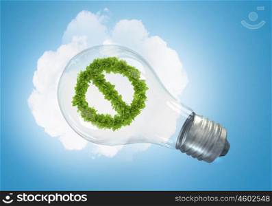 Energy saving concept. Conceptual image of green stop sign in glass bulb