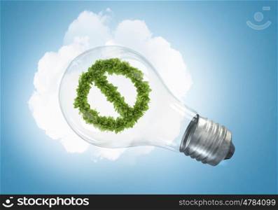 Energy saving concept. Conceptual image of green stop sign in glass bulb