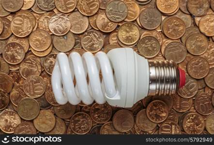 Energy saving light bulb on coins background