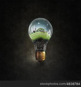 Energy saving. Think green concept with cityscape inside of light bulb