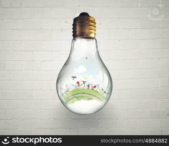 Energy saving. Think green concept with cityscape inside of light bulb