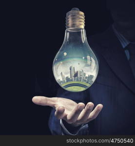 Energy saving. Think green concept with modern cityscape inside of light bulb