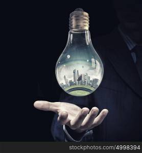 Energy saving. Think green concept with modern cityscape inside of light bulb