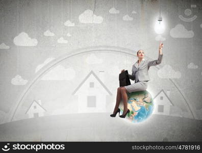 Energy saving. Young businesswoman sitting on Earth planet. Elements of this image are furnished by NASA