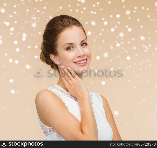 engagement, celebration, wedding and happiness concept - smiling woman in white dress wearing diamond ring over beige background and snow