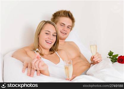 Engagement ring - couple in bed with champagne together